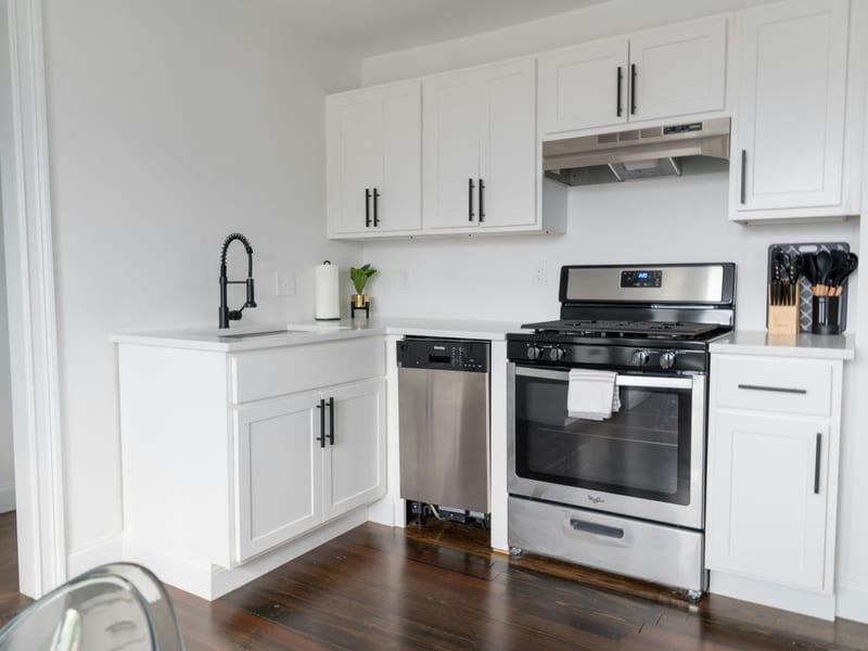 A fitted kitchen with a built-in dishwasher beside a gas range and a wooden worktop