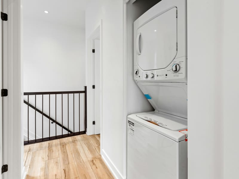 A stacked washer and dryer in a hallway closet